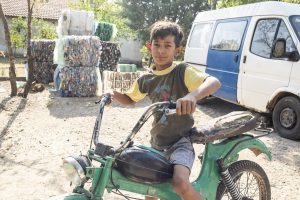 Ercan enjoys riding his father's old motorbike during his free time. Now he has to help his father working with the trash they gather.